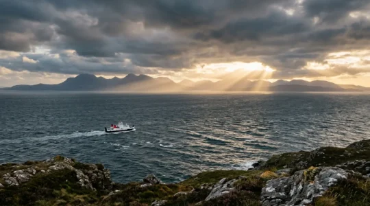 CalMac ferry navigating through misty Hebridean waters at golden hour