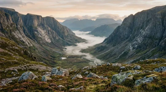 Misty morning view of a U-shaped glacial valley in the Scottish Highlands with characteristic steep valley walls and flat floor