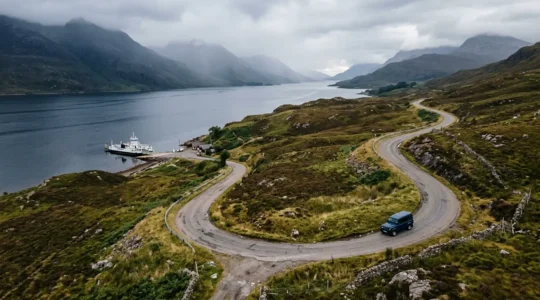 Scenic Scottish Highlands road with ferry view and budget planning elements