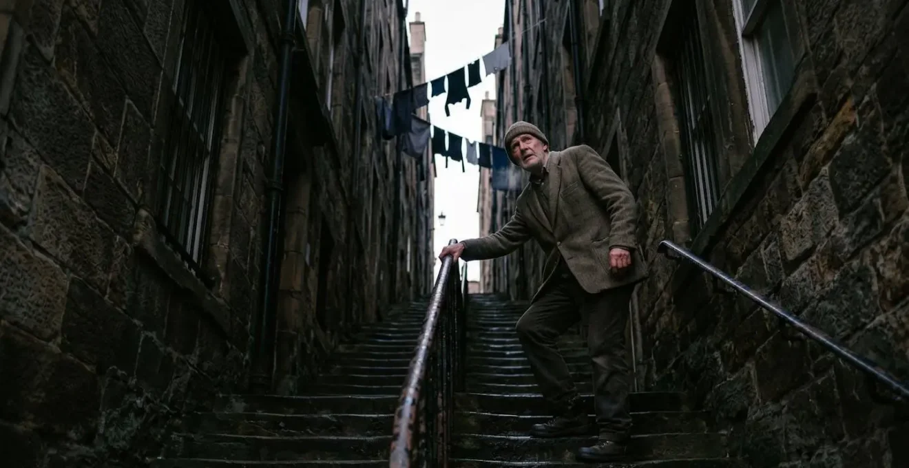 Steep narrow close between tall stone tenements in Edinburgh Old Town