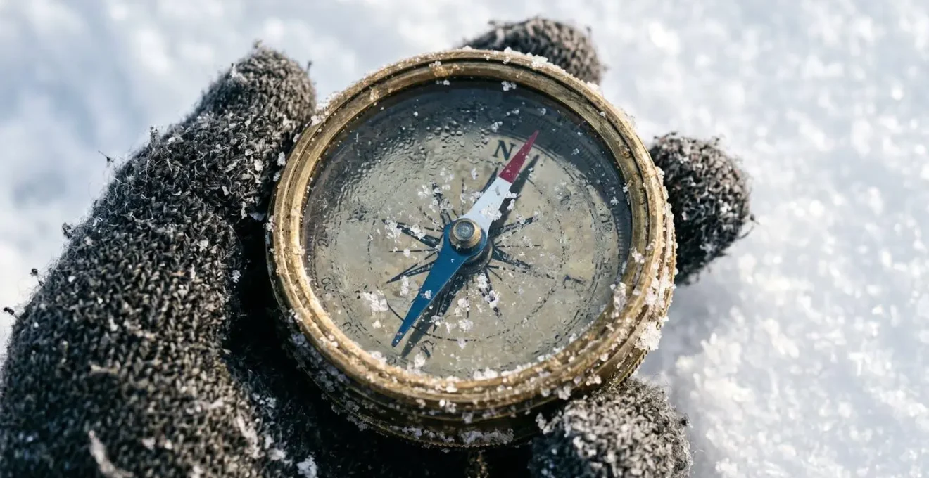Extreme close-up of compass needle on snowy surface with ice crystals